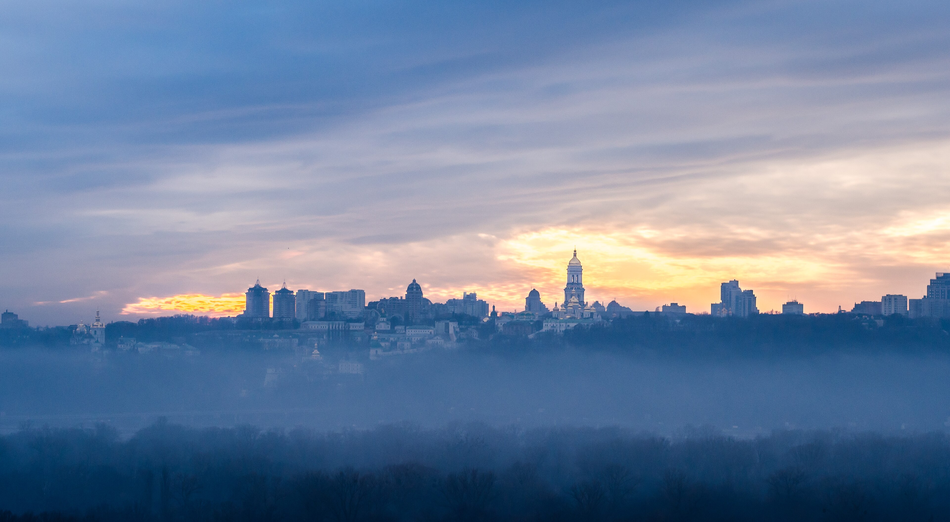 City skyline at dawn under low fog