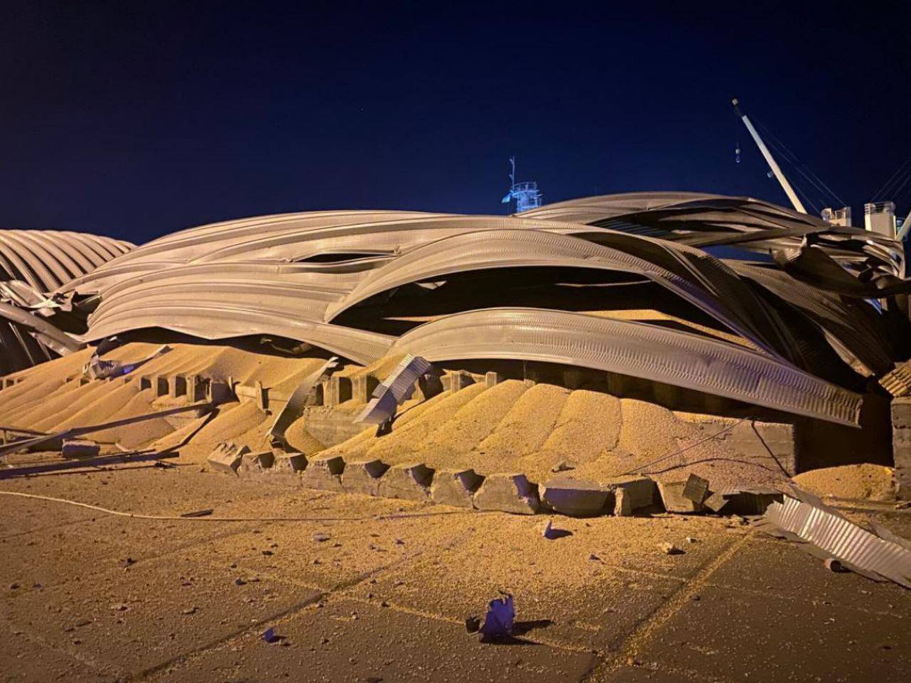 A collapsed grain-terminal roof with grain spilling beneath it