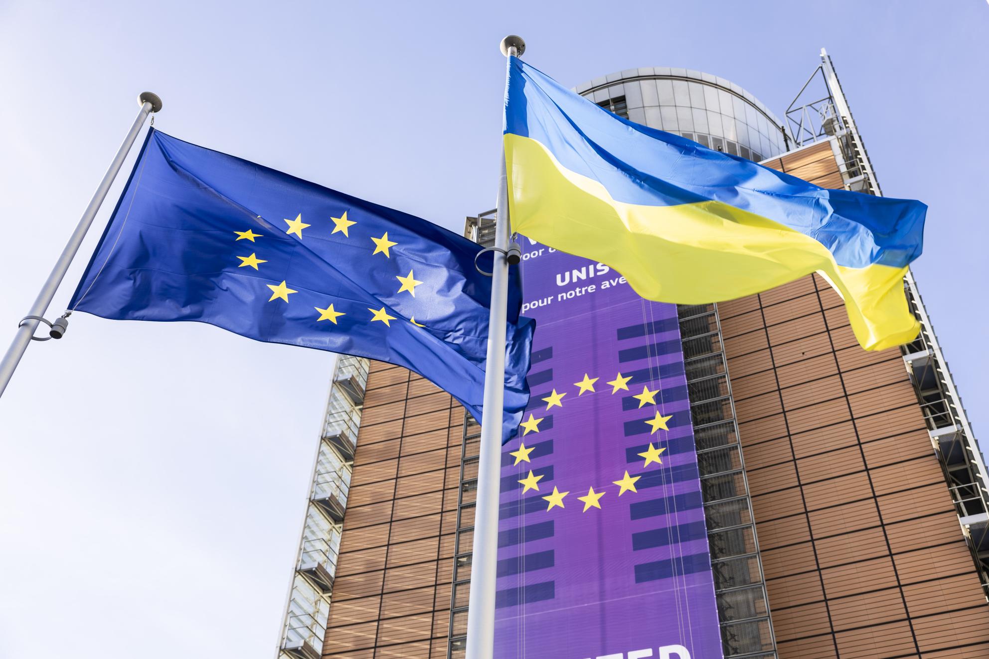 Two flags flying outside an institutional building