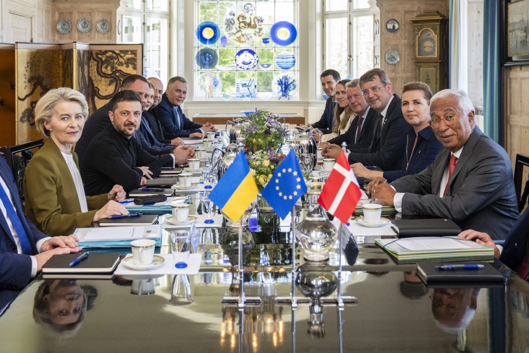 Officials seated around a long meeting table